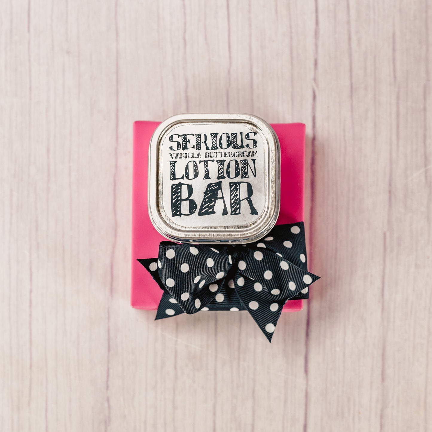 A vanilla buttercream lotion tin is packaged with a Sampler box of divine Assorted Chocolates 