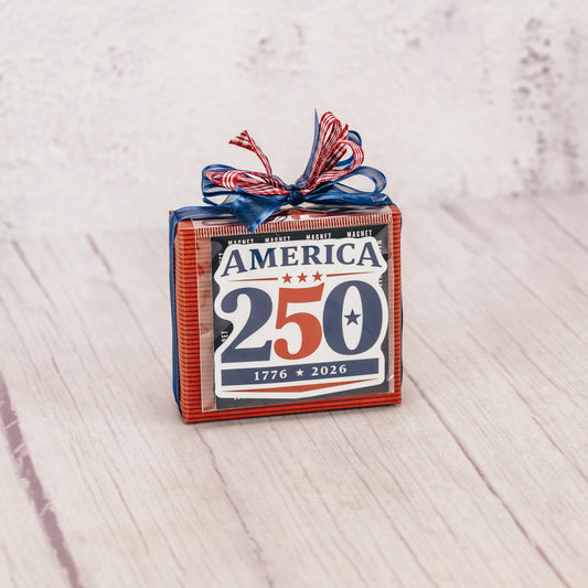 a sampler box of assorted chocolates is wrapped and topped with a magnet that reads 'American 250 - 1776-2026'