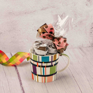 a colorful mug is filled with a half pound of our delightful assorted chocolates