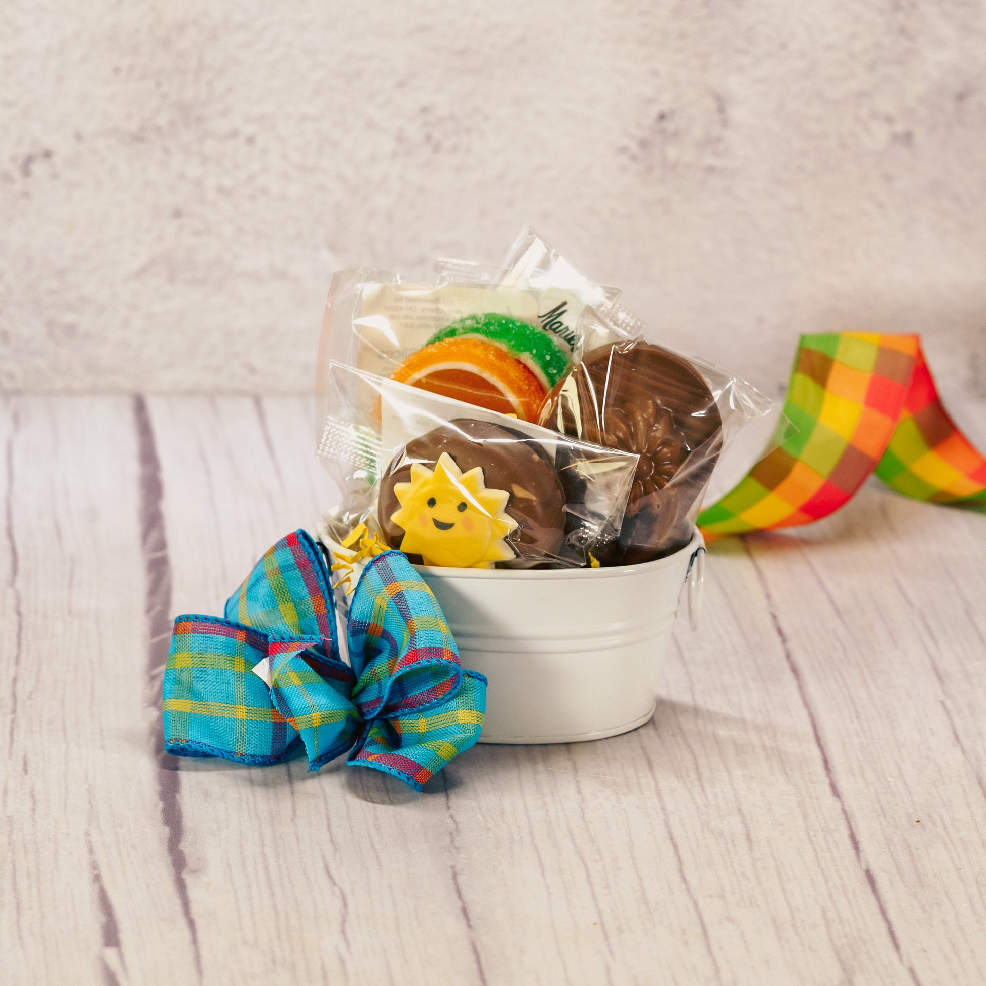 a small white metal bucket is filled with sweet summer treats!