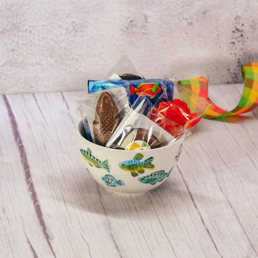 a small snack bowl or ice cream bowl with colorful fish all over is filled with sweet summer treats