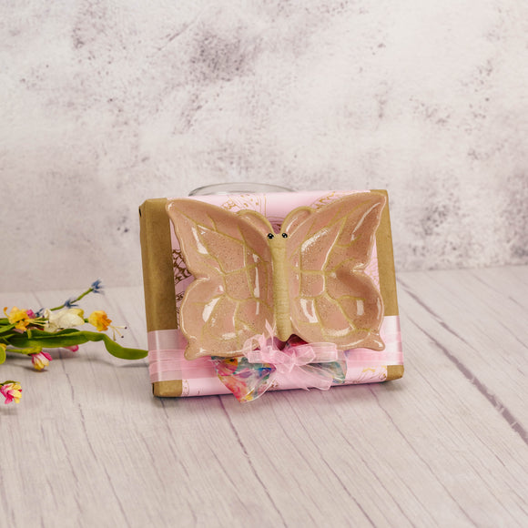 a half pound box of assorted chocolates is wrapped and topped with a ceramic butterfly vanity tray