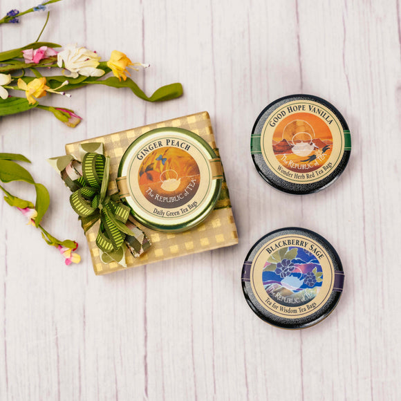 a sampler box of assorted chocolates is topped with a tea travel tin (6 teabags), three tea varieties.