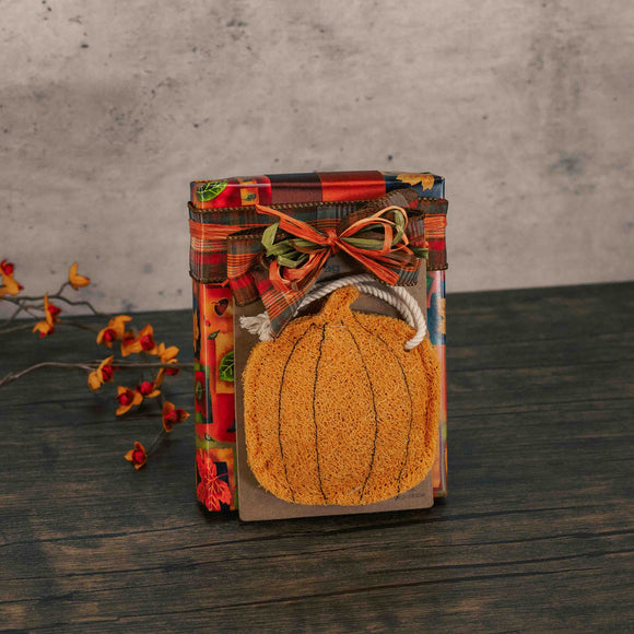 a half pound box of assorted chocolates is wrapped in fall paper and topped with a pumpkin loofah kitchen scrubber