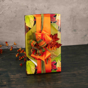 a one pound box of assorted chocolates is wrapped in fall leaf paper and topped with a handmade bow and decorative leaves. Choose milk or milk and dark