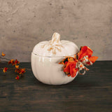 a white pumpkin candy bowl with lid is filled with fall sweet treats