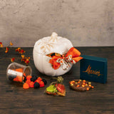 a white pumpkin candy bowl with lid is filled with fall sweet treats