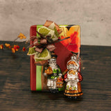 a half pound box of assorted chocolates is topped with a glass girl or boy pilgrim ornament