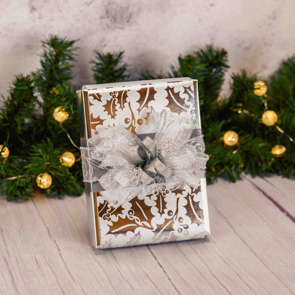 a half pound box of milk chocolates or a combination of milk and dark chocolates is wrapped in shiny silver holly paper and tied with a stunning silver handmade bow