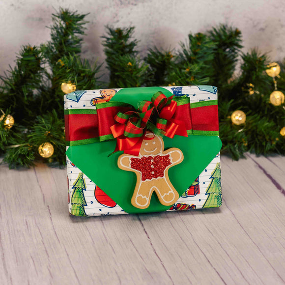 a half pound box of assorted chocolates is wrapped and topped with a flat wooden gingerbread man ornament