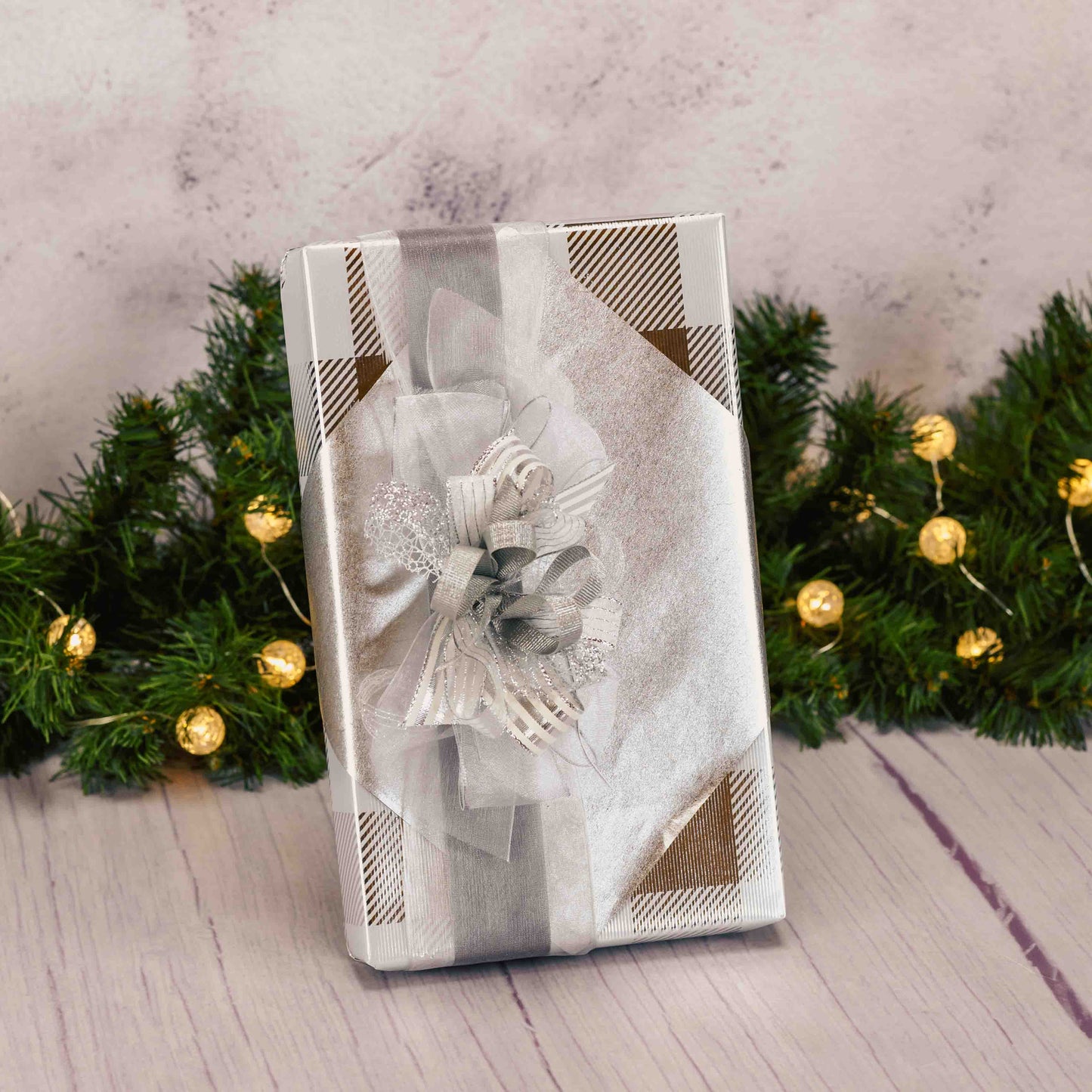 a one pound box of assorted chocolates wrapped in silver and topped with a lovely handmade bow. 