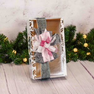 a two pound box of assorted chocolates wrapped in sparkly silver wrap and topped with a stunning pink and silver handmade bow