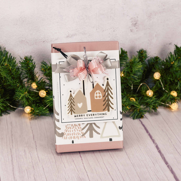 a one pound box of assorted chocolates is topped with a ceramic keepsake ornament that reads 'merry everything'