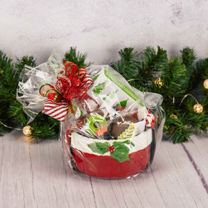 a red ceramic bowl with spreader knife is filled with festive treats