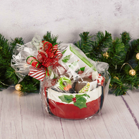 a red ceramic bowl with spreader knife is filled with festive treats