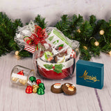 a red ceramic bowl with spreader knife is filled with festive treats