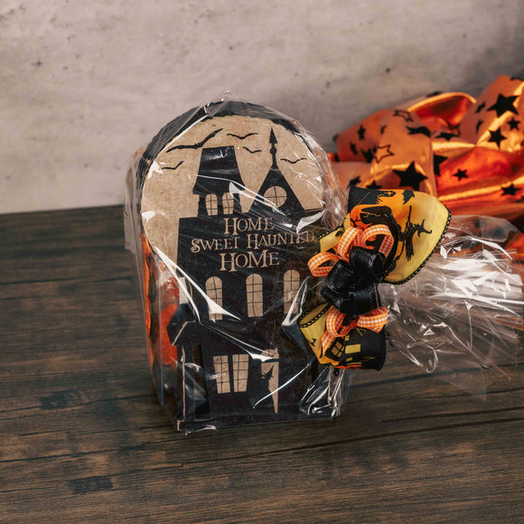 a wooden decorative block that reads 'home sweet haunted home' is packaged with candy