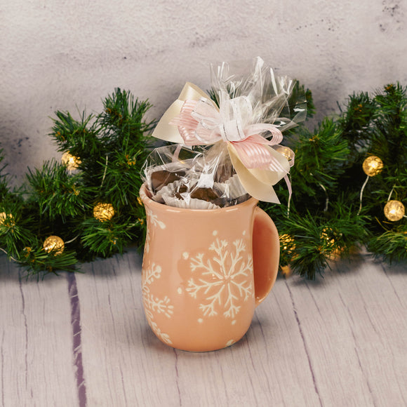 a pink snowflake handwarmer mug is filled with over a half pound of assorted milk chocolates