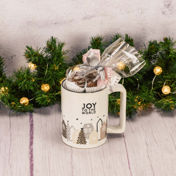 modern styled mug with pink and gray house and trees that reads 'joy to the world' and is filled with a half pound of our assorted milk chocolates.