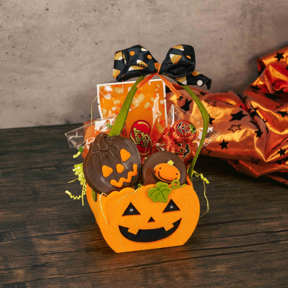 a small felt jack-o-lantern basket is filled with sweet treats