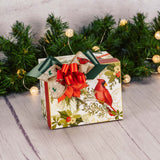 a small gift box with cardinal and winter greenery is filled with some sweet treats