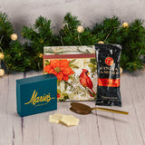 a small gift box with cardinal and winter greenery is filled with some sweet treats
