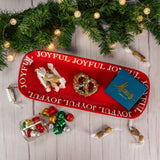 a red platter that reads 'joyful' around the edges is filled with candy 