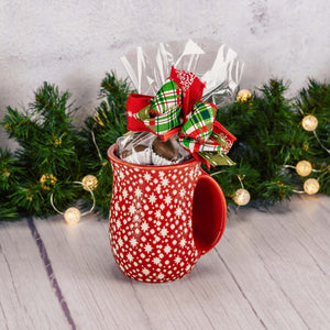 a hand warming mug is filled with over a half pound of assorted milk chocolates. Choose a red or green mug
