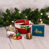 a red ceramic bowl with spreader knife is filled with festive treats