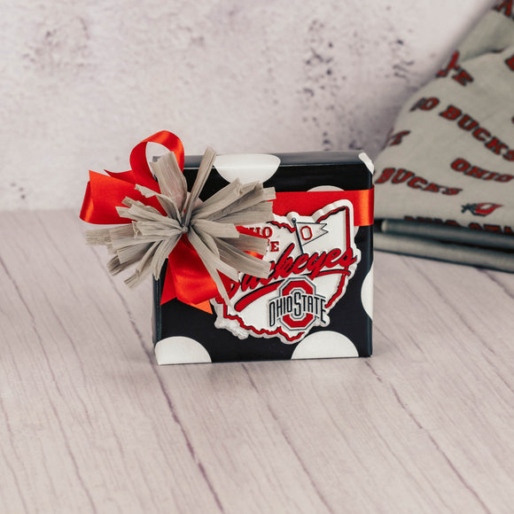 a sampler box of assorted chocolates is topped with an Ohio State Buckeyes magnet
