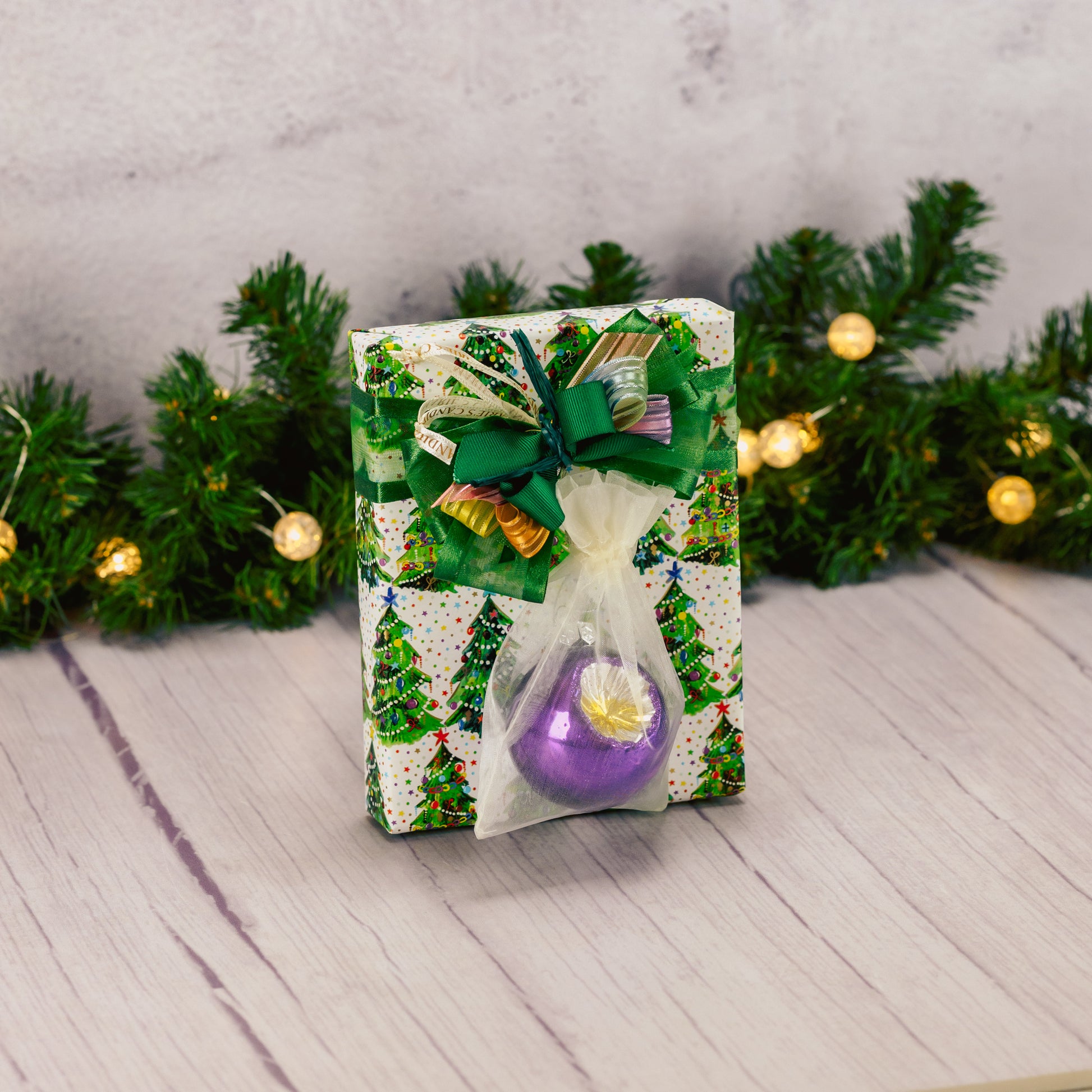 a half pound box of assorted chocolates is wrapped and topped with a vintage colorful ball ornament.
