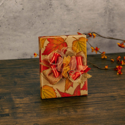 a half pound box of assorted chocolates is wrapped in fall leaf paper and topped with a handmade bow.