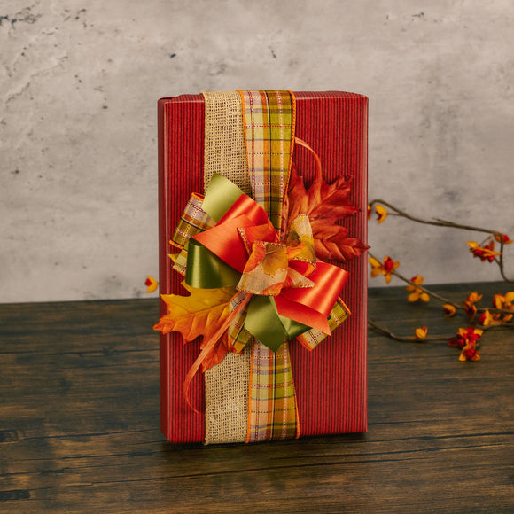 a one pound box of assorted chocolates wrapped in fall paper and tied with a handmade bow with faux leaves