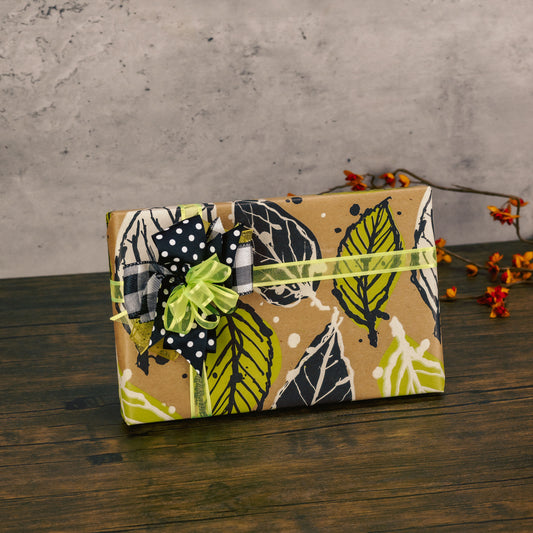 a half pound box of sugar free assorted chocolates is wrapped in fall leaf paper and topped with a handmade bow