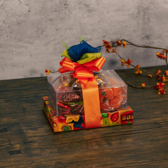 a small fall themed gift stack is wrapped in fall with sweet treats