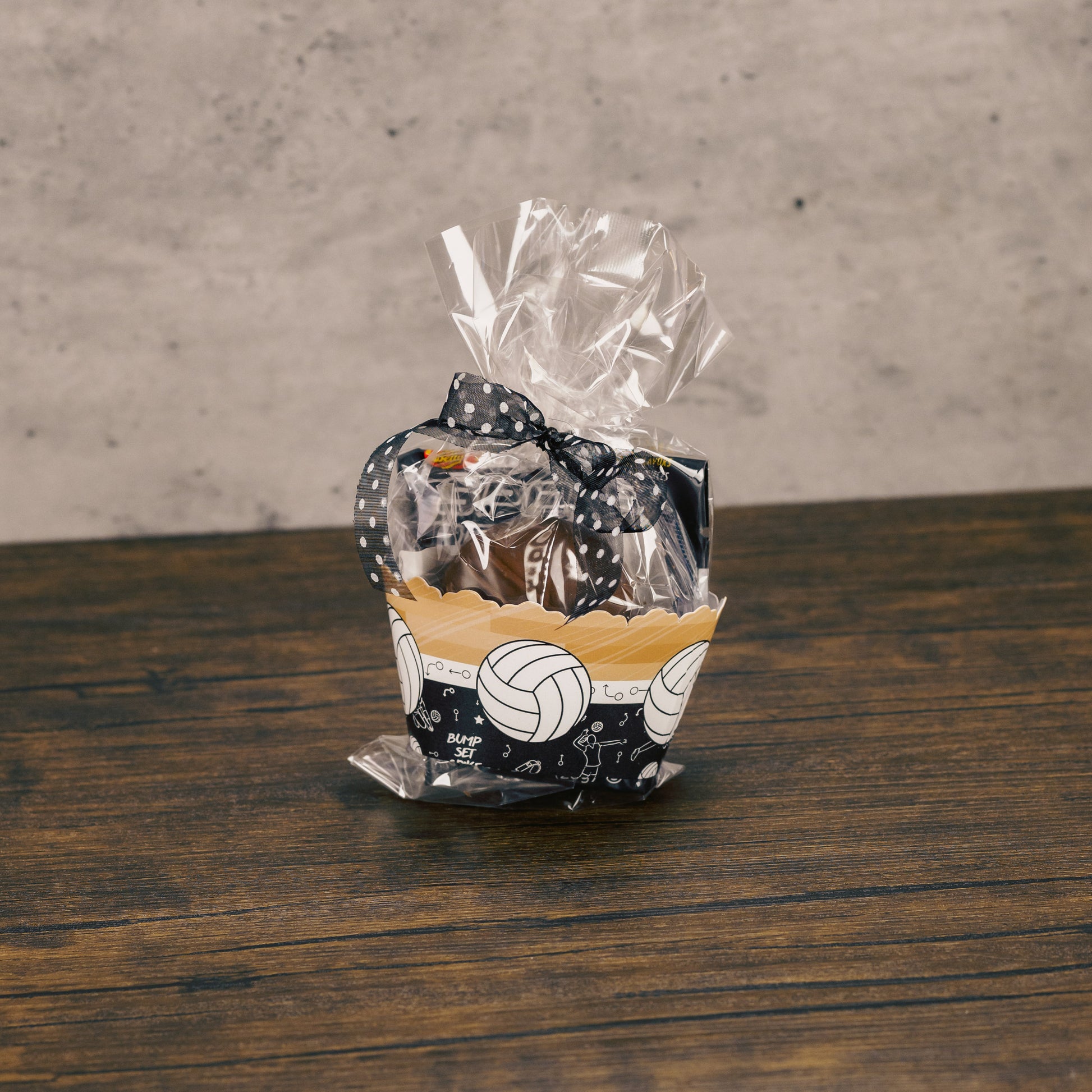 a clear cello bag filled with candy and at paper volleyball cuff around it.