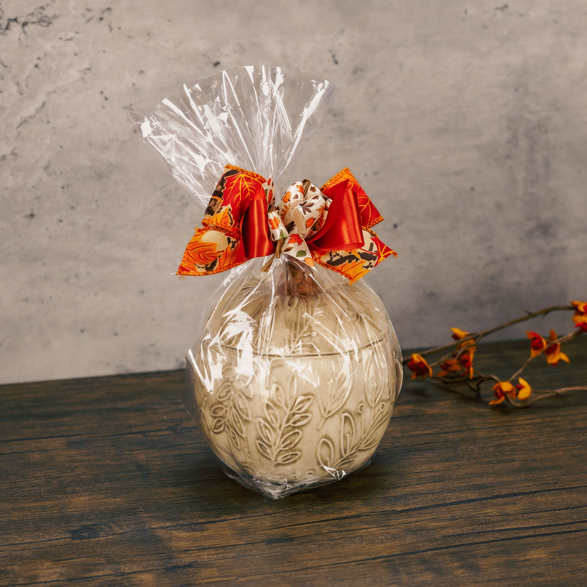a ceramic pumpkin candy bowl with lid is filled with festive fall treats. assorted pumpkin colors. 