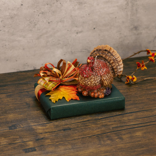 a half pound box of assorted chocolates is topped with a turkey candle