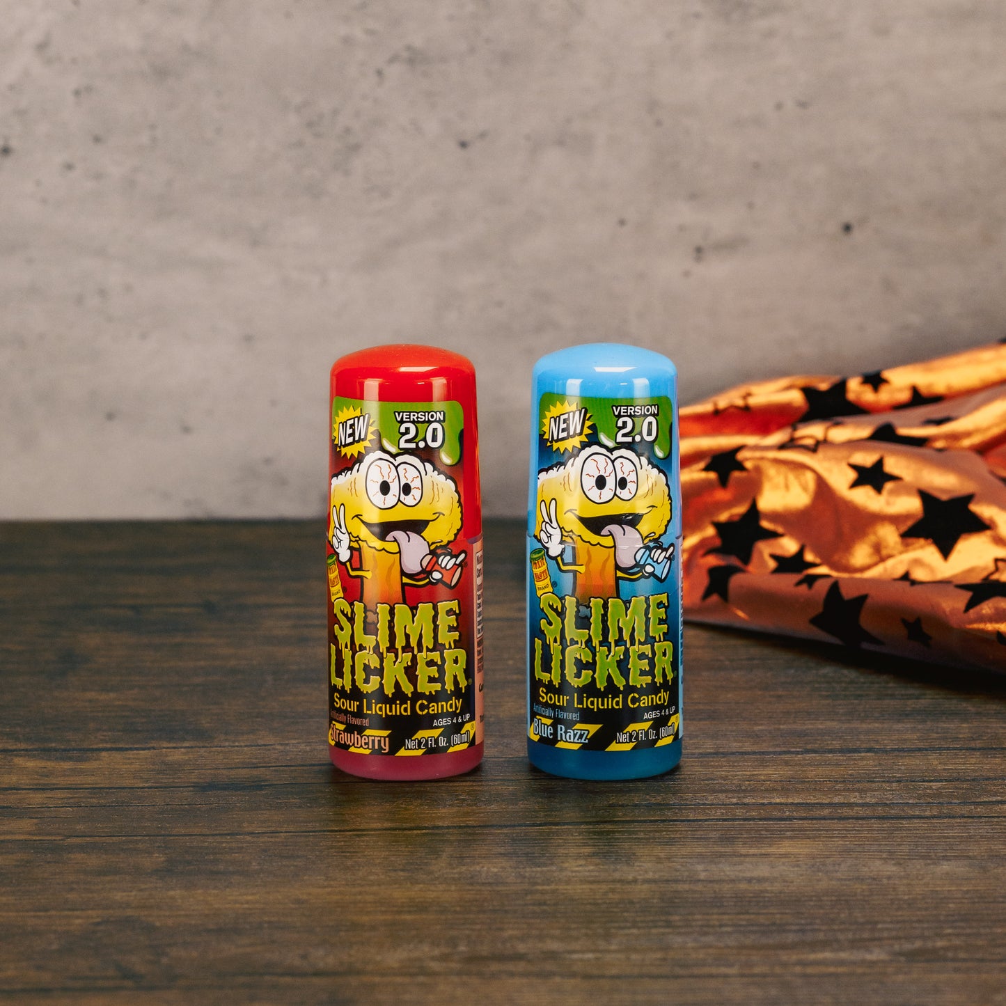 Slime Licker liquid sour candy in flavors Strawberry and Blue Razz, with a rolling ball top