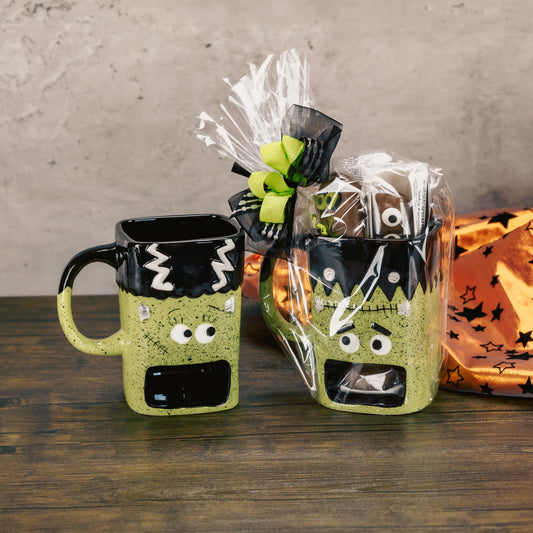 a frank or bride monster cookie mug filled with sweet treats. mug has an open spot to hold your cookies while you sip your favorite beverage.