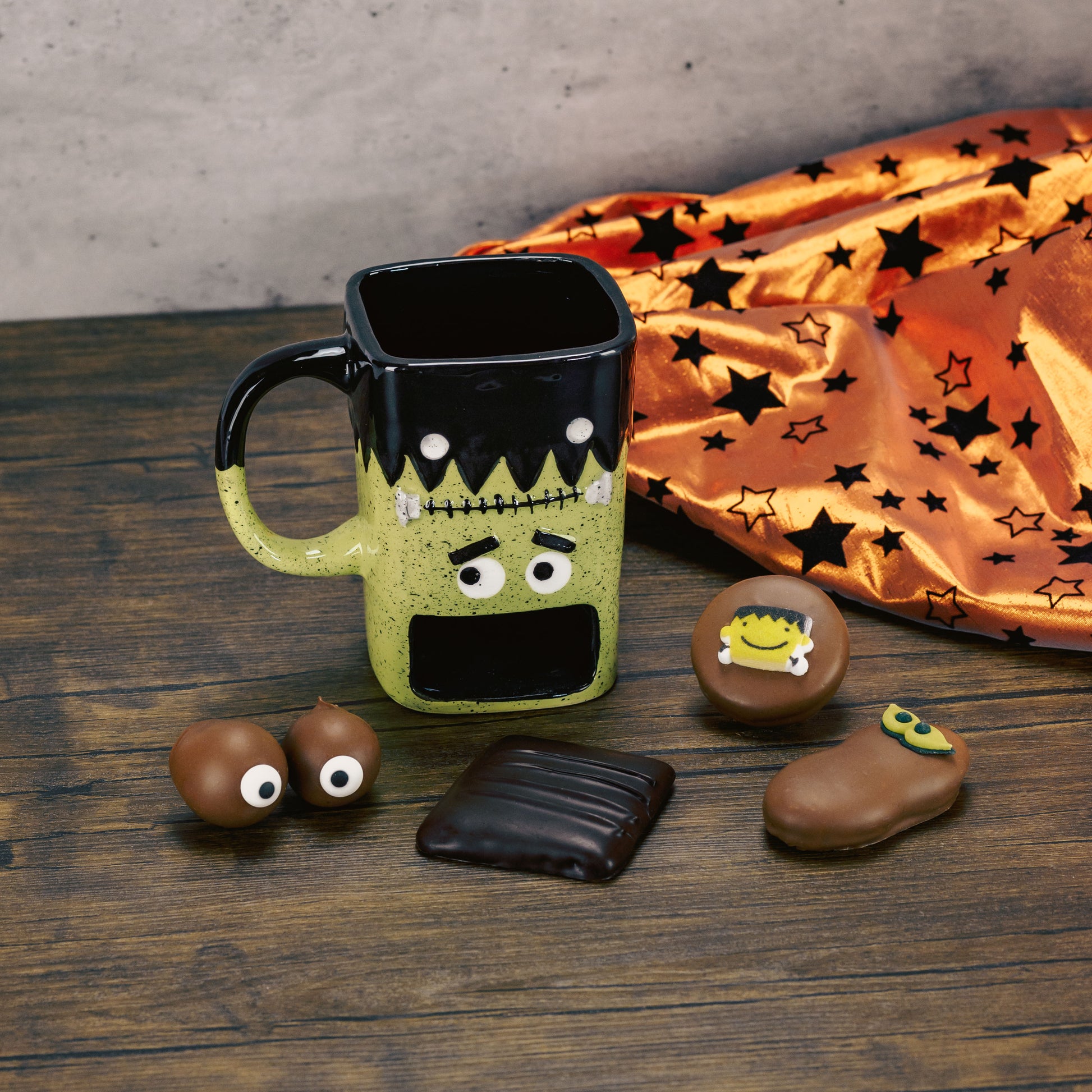 a frank monster cookie mug filled with sweet treats. mug has an open spot to hold your cookies while you sip your favorite beverage.