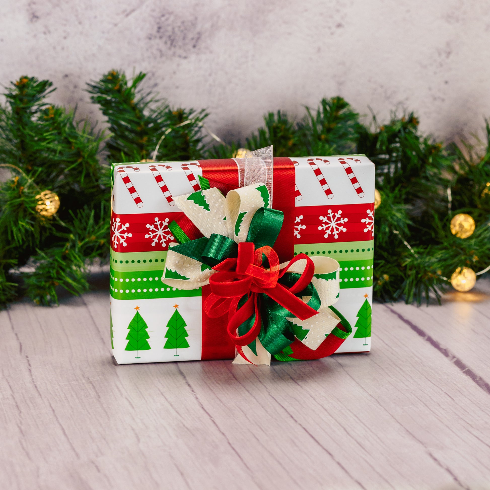 a half pound box of assorted chocolates is wrapped and bowed in red and greens.