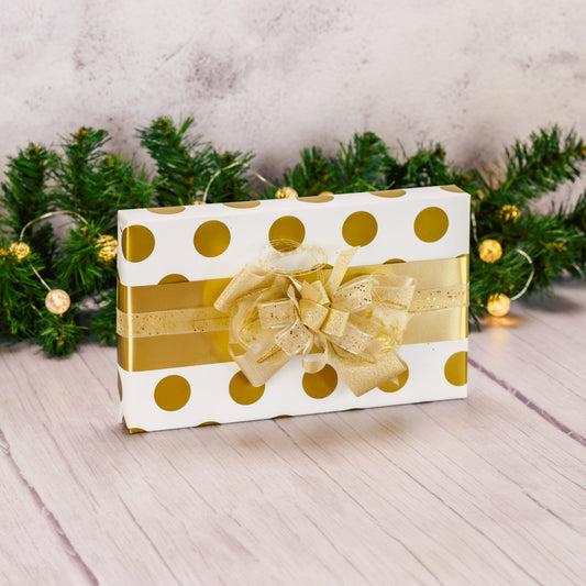 a one pound box of assorted chocolates is wrapped in white and gold and topped with a handmade bow. 