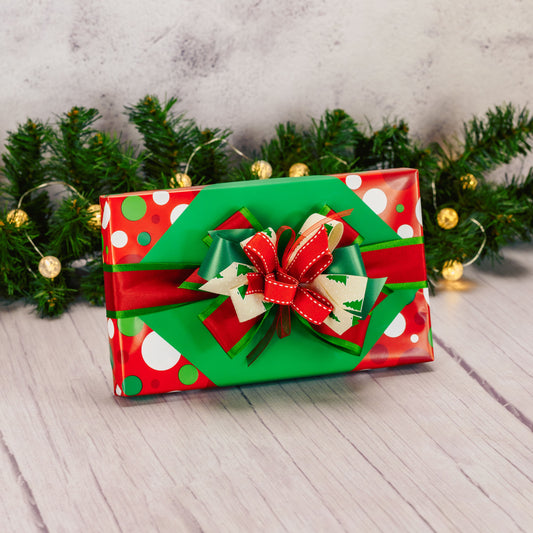 a one pound box of assorted chocolates is wrapped and bowed in green and red colors.