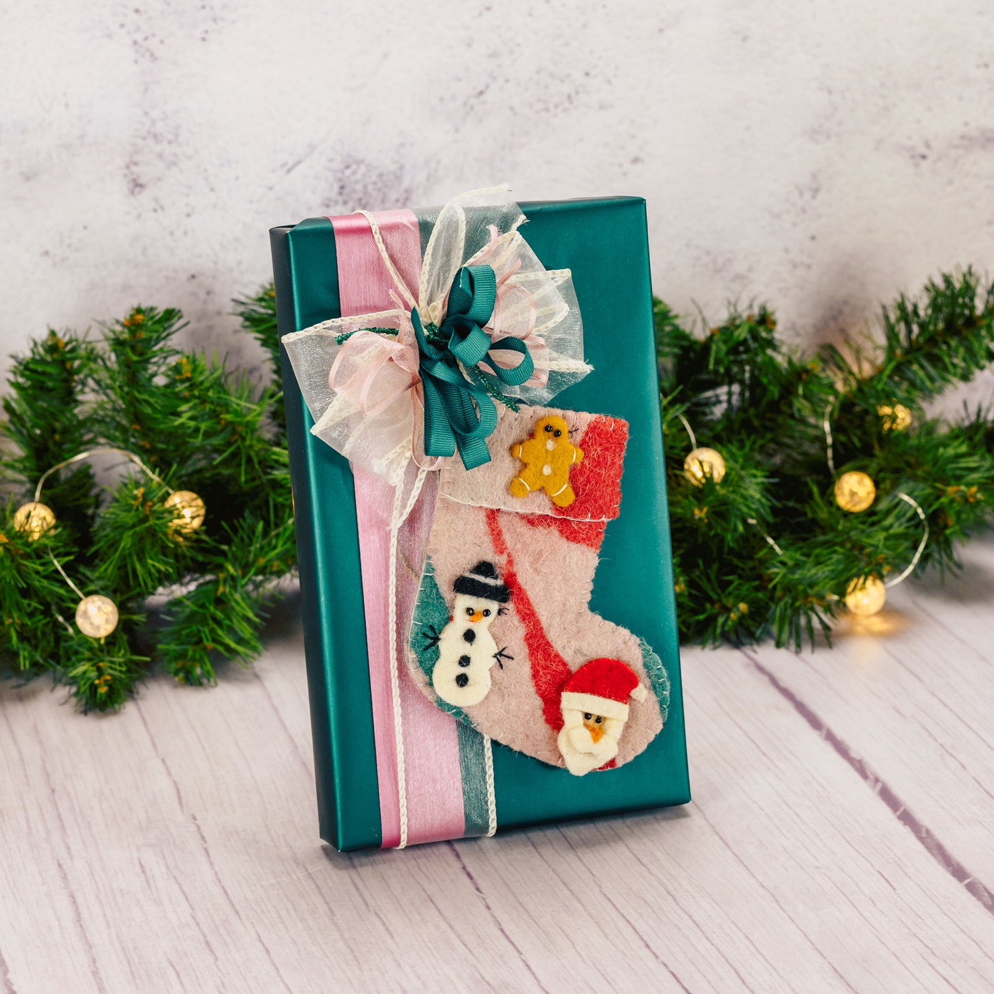 a one pound box of assorted chocolates with a felt stocking ornament packaged with it