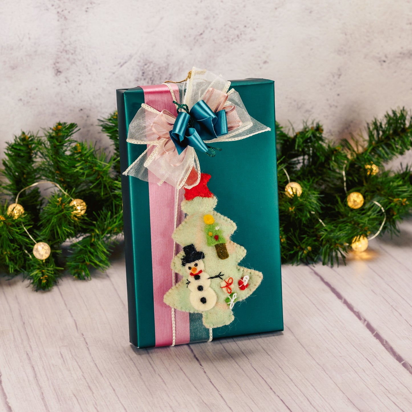 a one pound box of assorted chocolates with a felt tree ornament packaged with it