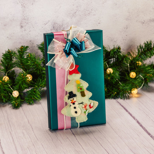 a one pound box of assorted chocolates with a felt tree ornament packaged with it
