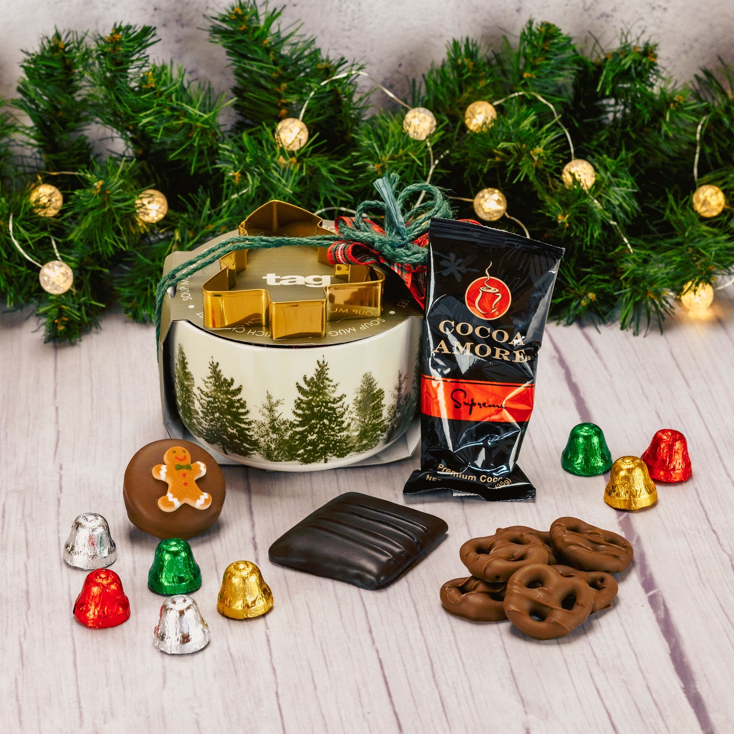 a soup mug with pine trees all around is filled with sweet treats and comes with a tree stencil, for cookies, sandwiches or coffee art. 