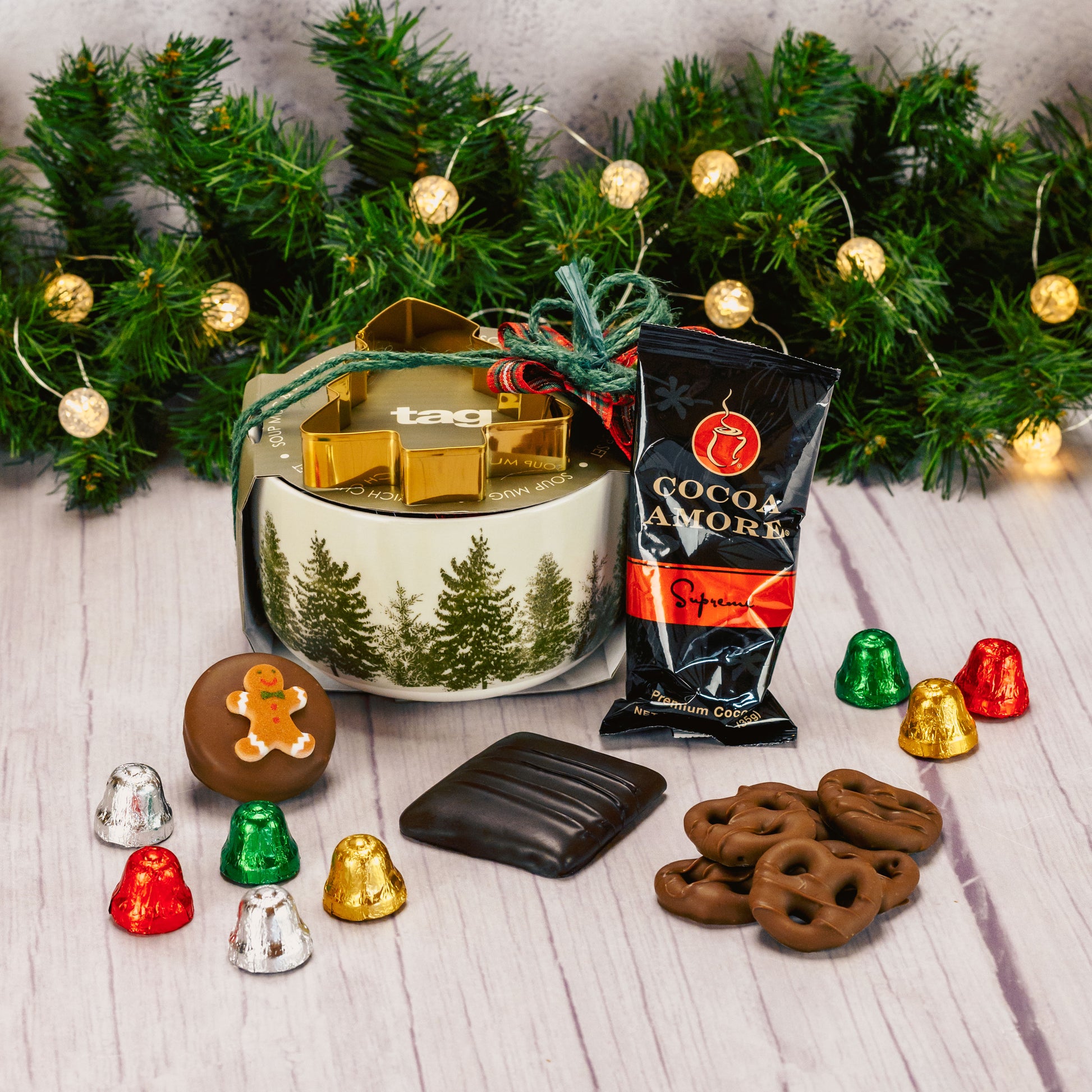 a soup mug with pine trees all around is filled with sweet treats and comes with a tree stencil, for cookies, sandwiches or coffee art. 