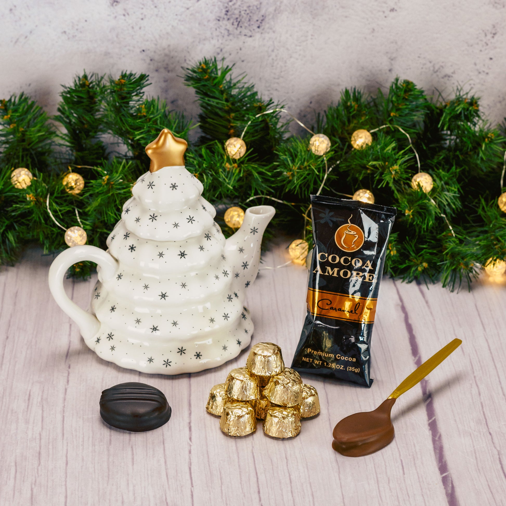 a white tree shaped teapot packaged with sweet treats